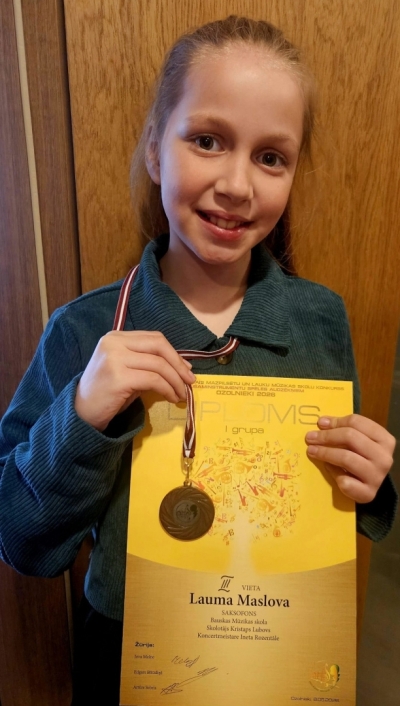 Meitene ar diplomu un medaļu